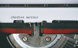 Spannende Wendungen schreiben; Papier in Schreibmaschine; auf dem Papier steht "Stories matter"
