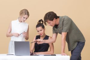 Feedback bekommen; zwei Leute geben einer dritten Person Feedback